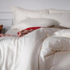 Luxurious white-striped cotton bedding, hypoallergenic and gentle on skin, designed for a chic and cozy bedroom look.
